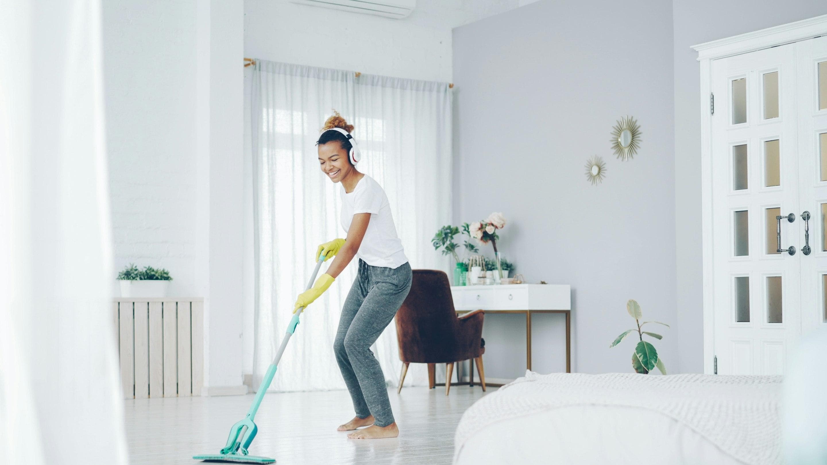 Person mopping the floor of a bedroom