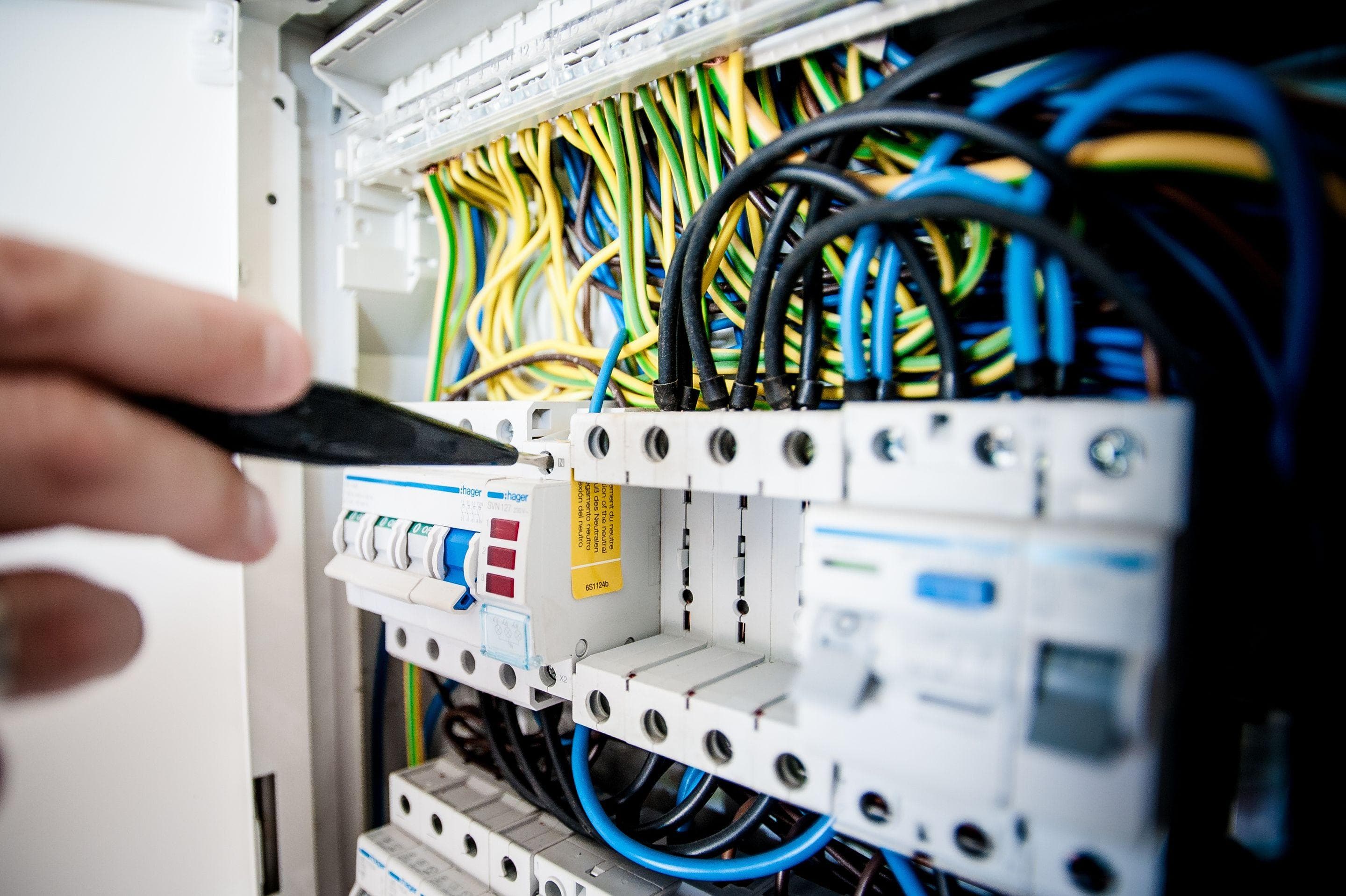 Hand using a screwdriver on a residential switchboard